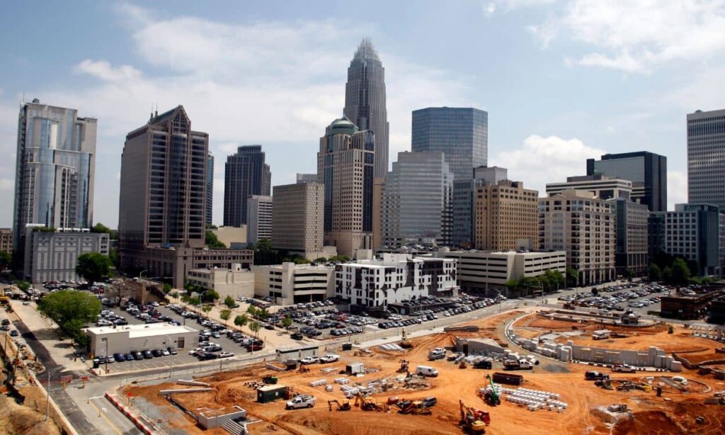 Downtown Charlotte NC skyline with ongoing construction of a vertical mixed-use development, illustrating the role of land surveyors in urban growth.”