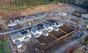 Aerial view of a residential construction site showing multiple houses under development, captured using drone surveying technology.