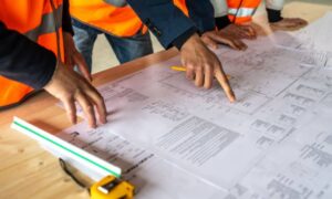 Surveyors reviewing construction survey plans to ensure stormwater compliance and site plan approval