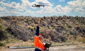 Licensed surveyor operating a drone for drone surveying in an outdoor land surveying site.