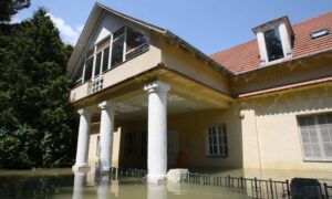 Flooded house showing rising water levels, highlighting the importance of a boundary survey to detect hidden flood risks.