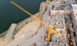 Aerial view of a commercial construction site with a yellow crane, showing land boundaries and layout preparation for an ALTA Title Survey