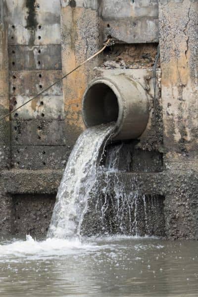 Stormwater drainage pipe discharging water as part of urban drainage design and flood control system
