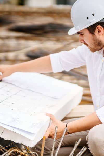 Civil engineer reviewing site plan - ALTA SURVEY North Carolina A civil engineer examining site blueprints that illustrate drainage and stormwater design planning for infrastructure projects