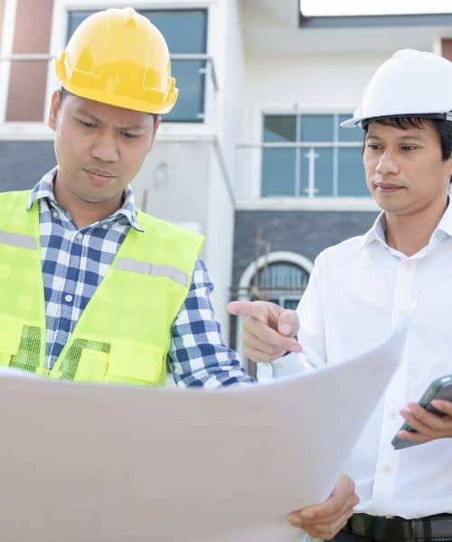 Engineers reviewing site drawings outdoors - ALTA SURVEY North Carolina Engineers reviewing site drawings as part of construction project management work on a building project