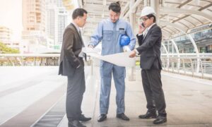 Project team reviewing blueprints on site as part of construction project management work