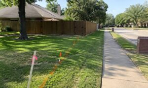 Corner lot fence installation with unclear property lines, homeowner checking boundary before hiring a land surveyor near me