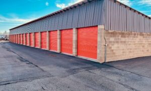 Self-storage building with red roll-up doors and a paved drive aisle, showing features documented in an ALTA survey for a facility transaction