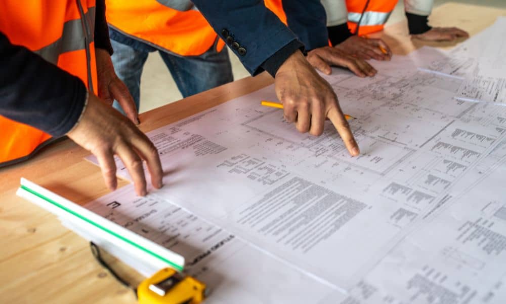 Surveyors reviewing construction survey plans to ensure stormwater compliance and site plan approval

