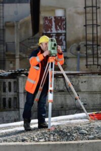 Licensed land surveyor using surveying equipment to conduct a boundary survey.
