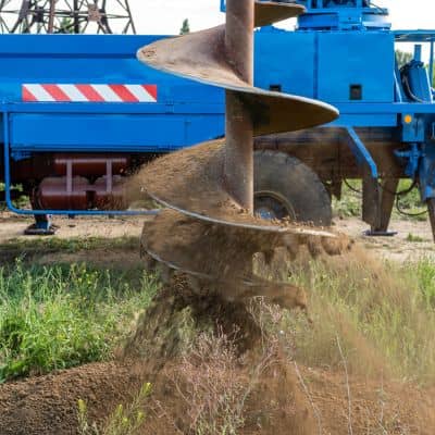 Land development engineer conducting soil drilling to evaluate ground conditions and site risk